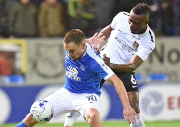 Gaby Zakuani tussles with Peterborough's Paul Taylor in the clash between the sides last month