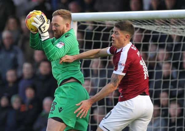NO WAY THROUGH - Bolton goalkeeper Ben Alnwick claims the ball under pressure from Cobblers striker Alex Revell (Pictures: Sharon Lucey)