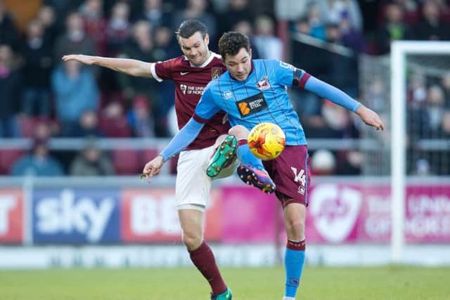 Zander Diamond battles for the ball against Scunthorpe