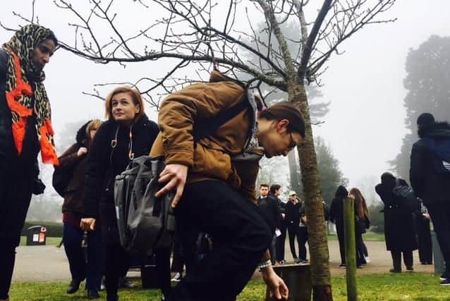 Students lay a stone at the Anne Frank and Stephen Lawrence memorial tree on Campus Park.