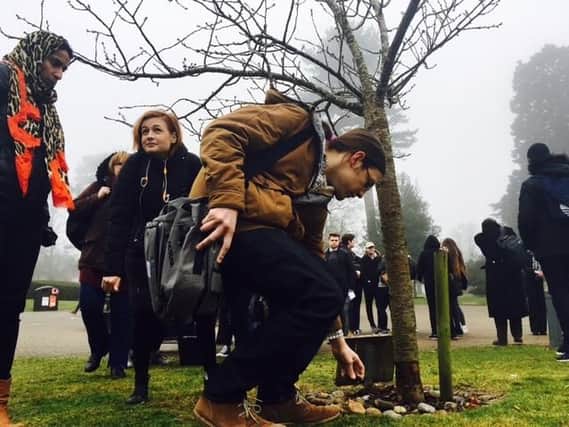 Students lay a stone at the Anne Frank and Stephen Lawrence memorial tree on Campus Park.