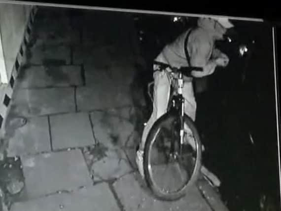 CCTV footage of a thief smashing a car window before he reaches into the car, grabs a handbag and makes a getaway on his pushbike.