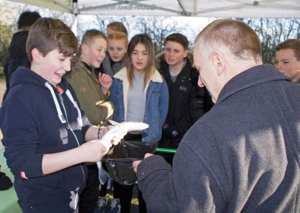 CRT fisheries boss John Ellis shows schoolchildren some eyeball contact with rescued fish