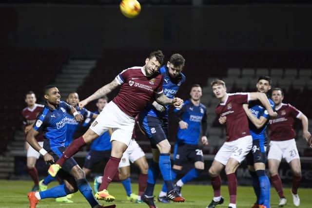 AERIAL BATTLE - Cobblers skipper Marc Richards tries to get on the end of a cross (Pictures: Kirsty Edmonds)