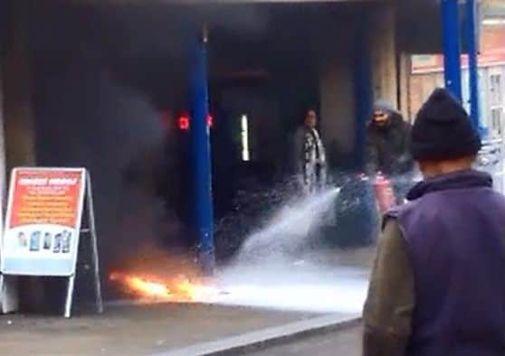 The minutes after the explosion as staff from nearby businesses tried to tackle the fire. Photo from a video sent in by Tom Pavela.