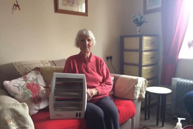 Marianne with her two-bar heater, which was all she had to heat her flat all winter.