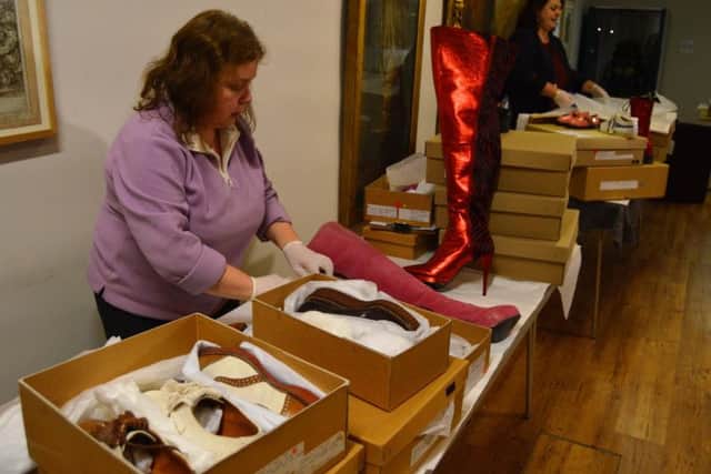 Volunteers packing shoes into boxes at the museum and art gallery