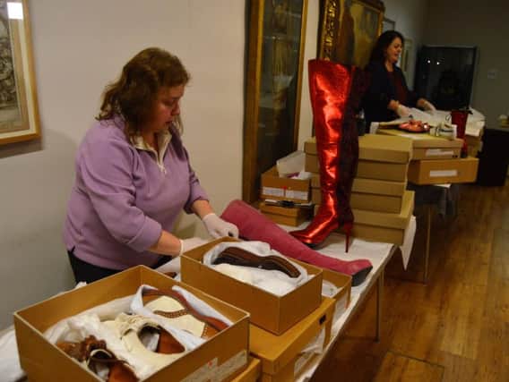 Volunteers packing shoes into boxes at the museum and art gallery