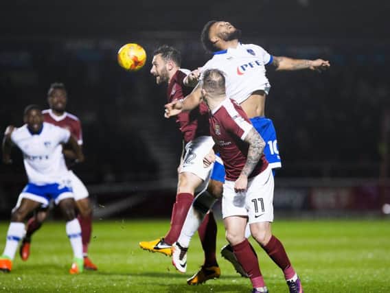 Neal Eardley wins this aerial battle during the Cobblers' clash with Oldham (Pictures: Kirsty Edmonds)