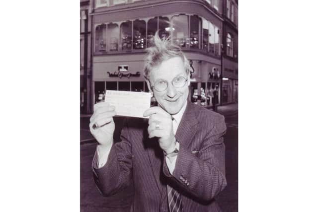 Mr Jones in front of his shop on Gold Street with a 100 cheque for the Northamptonshire Mind charity in 1989.