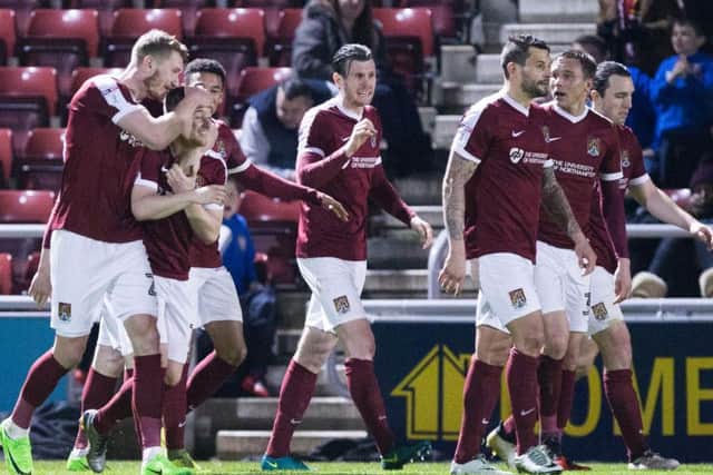 The Cobblers players celebrate Aaron Phillips' opening goal