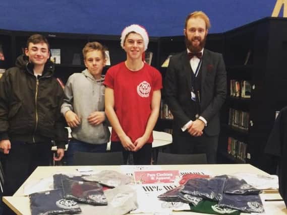 Chalie, in red, wearing his own branded clothing at a business fare at The Duston School.
