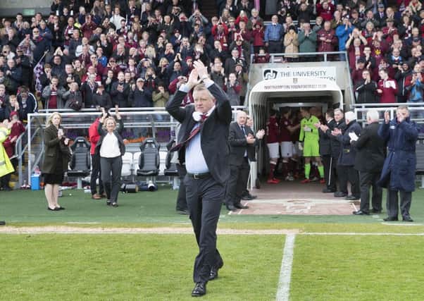 Chris Wilder walks out on to the Sixfields pitch ahead of the presentation of the league two title trophy last April