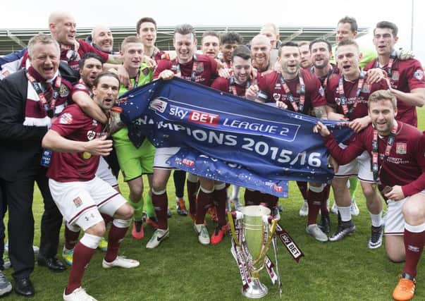 Chris Wilder celebrates the Cobblers' title success with the players at Sixfields last season