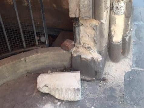 The stonework has been worked loose and the railings have been bent inwards.