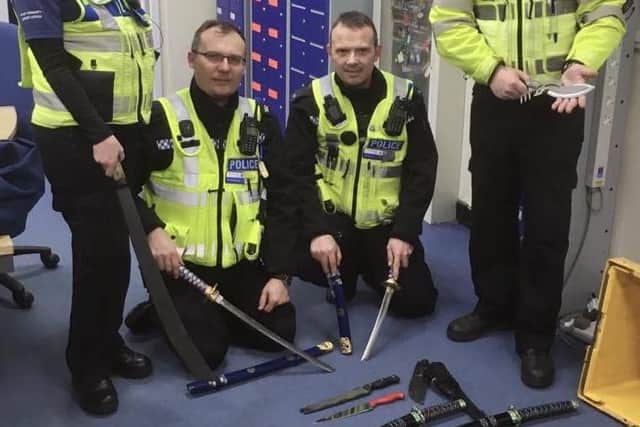 Officers pose with some of the knives handed in at a recent amnesty.