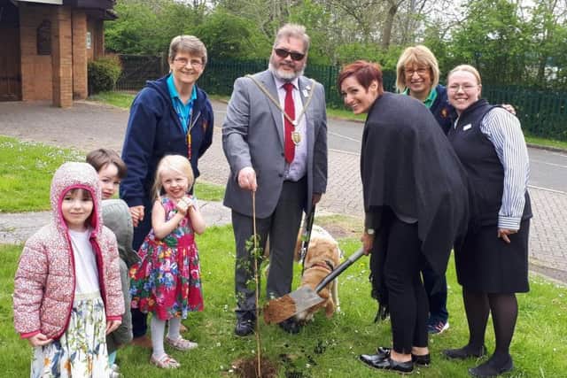Mayor Chris Malpas and the pre-school's children help plant the ceremonial tree.