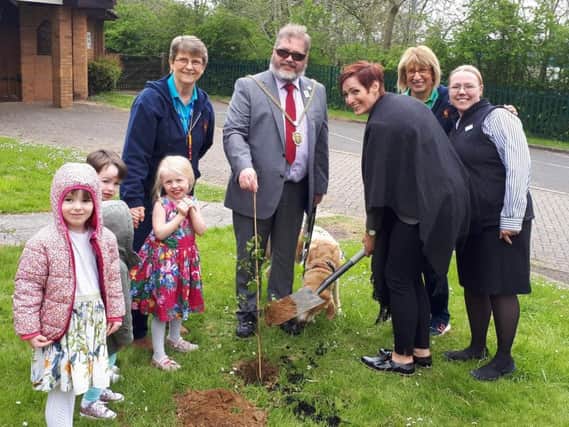 Mayor Chris Malpas and the pre-school's children help plant the ceremonial tree.
