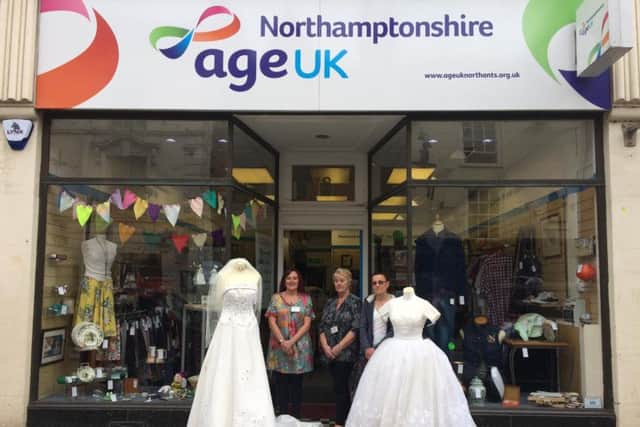 The ladies at the AgeUk store in St Giles Street with two of their vintage dresses.