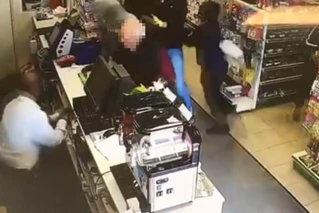 The three robbers burst into Ecton Brook Post Office on May 2. One of the gang has a gun pointed at shopkeeper Bipin Patel...