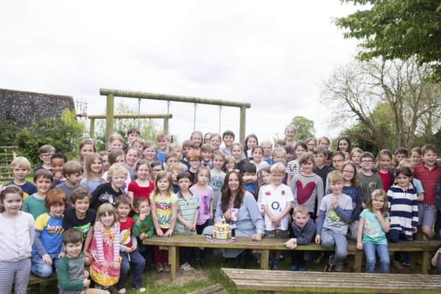 School pupils gathered around Mrs Truslove for a picture with her special cake.