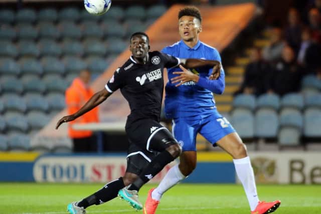 Leon Barnett tussles with Peterborough United's Lee Angol while playing for Wigan in 2015