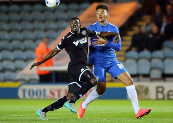 Leon Barnett tussles with Peterborough United's Lee Angol while playing for Wigan in 2015