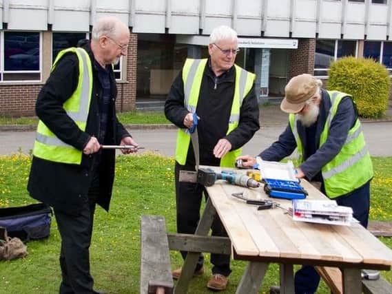 The Northampton Men's Sheds team work on a bench.