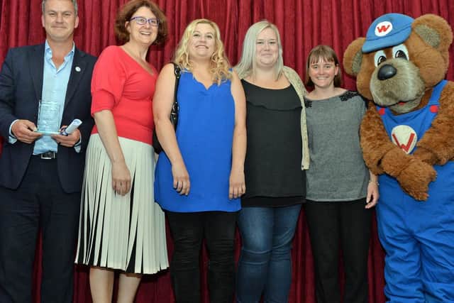 Staff from St Andrew's CofE Primary School in Kettering receive their award from Wicky Bear