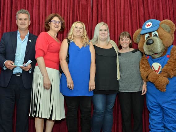 Staff from St Andrew's CofE Primary School in Kettering receive their award from Wicky Bear