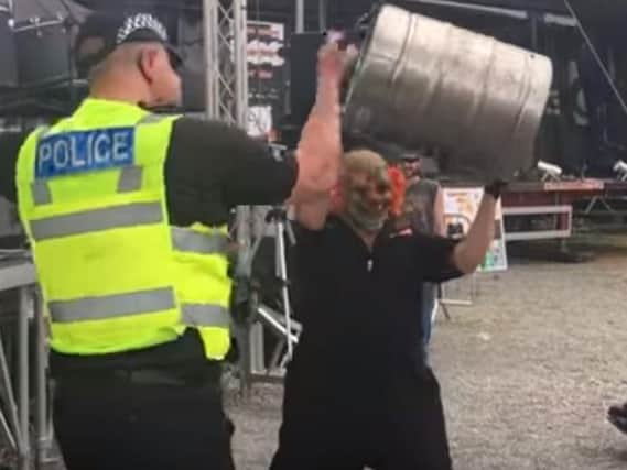 A police officer gets stuck in at Sixfields Rock Festival.
