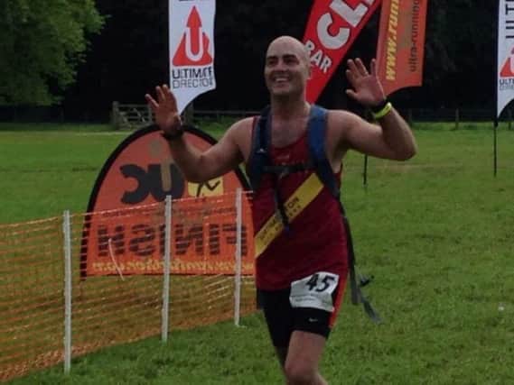 Andy Cottrell at the finishing line of another race on his journey to finishing 100 marathons.