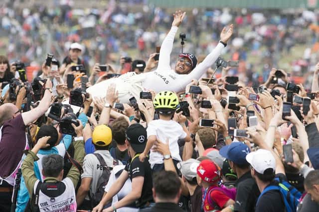 Lewis Hamilton crowdsurfs after his fourth consecutive British GP win