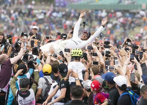 Lewis Hamilton crowdsurfs after his fourth consecutive British GP win