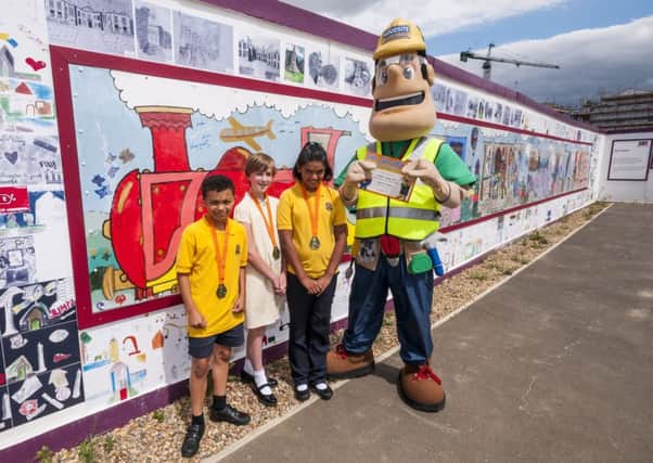 Pupils from Delapre Primary School with the hoarding featuring their artwork on the 'Waterside Express'