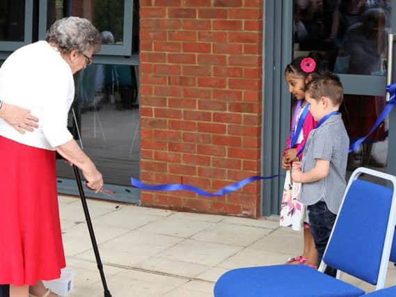 91-year-old Phyllis Wood, who is Moulton's oldest resident, snips the ribbon at the new centre.