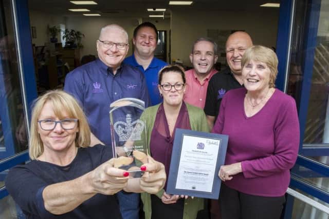 DACT workers proudly show off their Queen's Award for Voluntary Service at their Daventry headquarters. Picture: Kirsty Edmonds