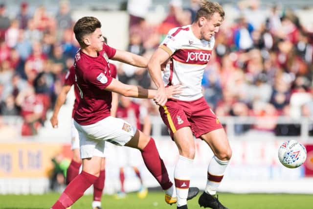 Regan Poole challenges for the ball with Bradford City striker Charlie Wyke
