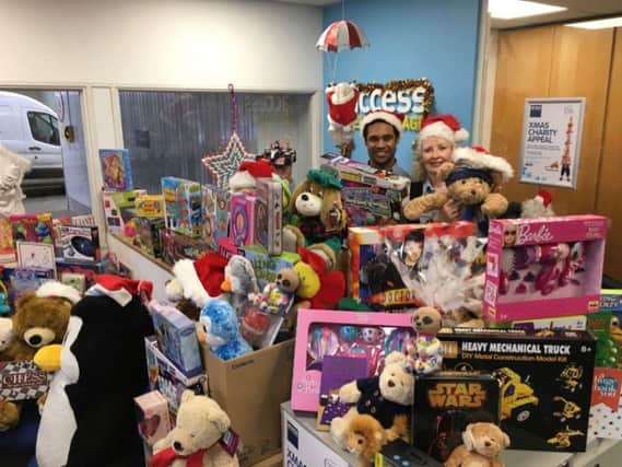 Some of the gifts collected in last years Access Self Storage Christmas Charity Appeal, with team membersJulian Hamilton Advisor and Deslynn Barter.