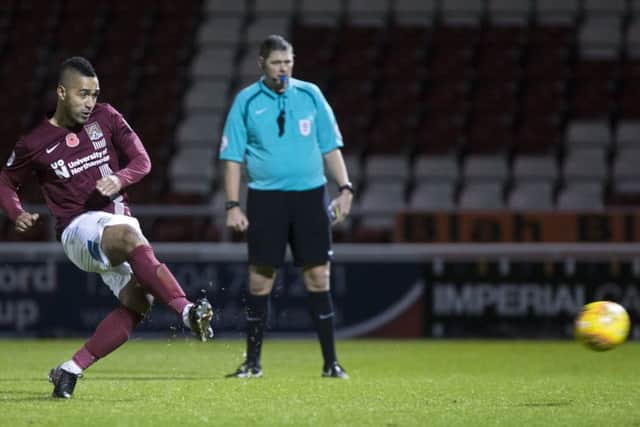 ON THE SPOT - Lewis McGugan slots home the winning kick in Tuesday's penalty shootout
