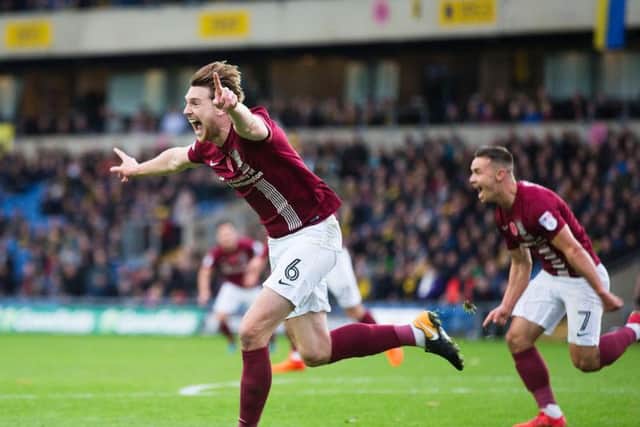 Ash Taylor wheels away in delight after firing the Cobblers into an early lead